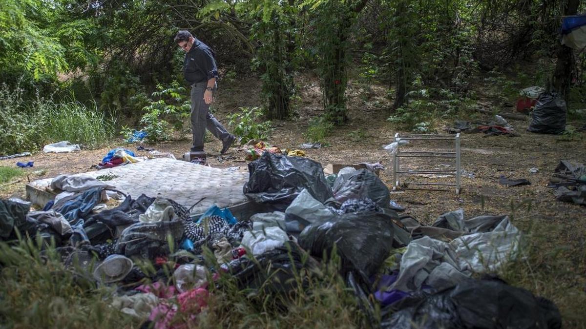 Sacramento County Supervisor Phil Serna walks along the American River Parkway, past a homeless encampment.