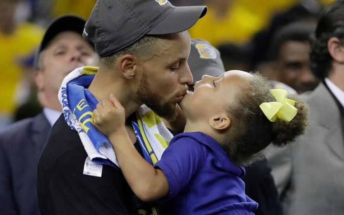 Golden State Warriors guard Stephen Curry kisses his daughter Riley as the team celebrates its championship victory over the Cleveland Cavaliers.