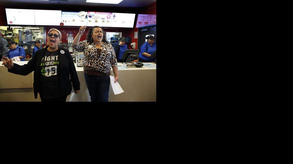 
Protesters demonstrate Thursday inside a McDonald’s in Los Angeles, demanding that a wage increase also include workers at franchise restaurants. 
