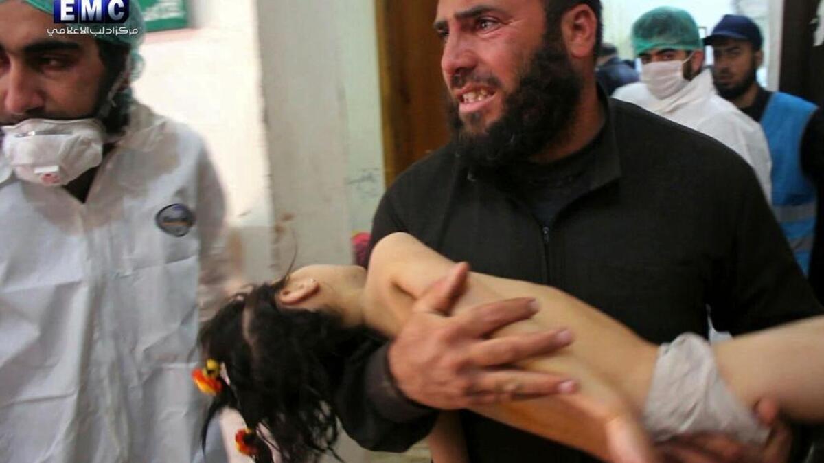 A man carries a child following a suspected chemical attack in Syria’s northern Idlib province.