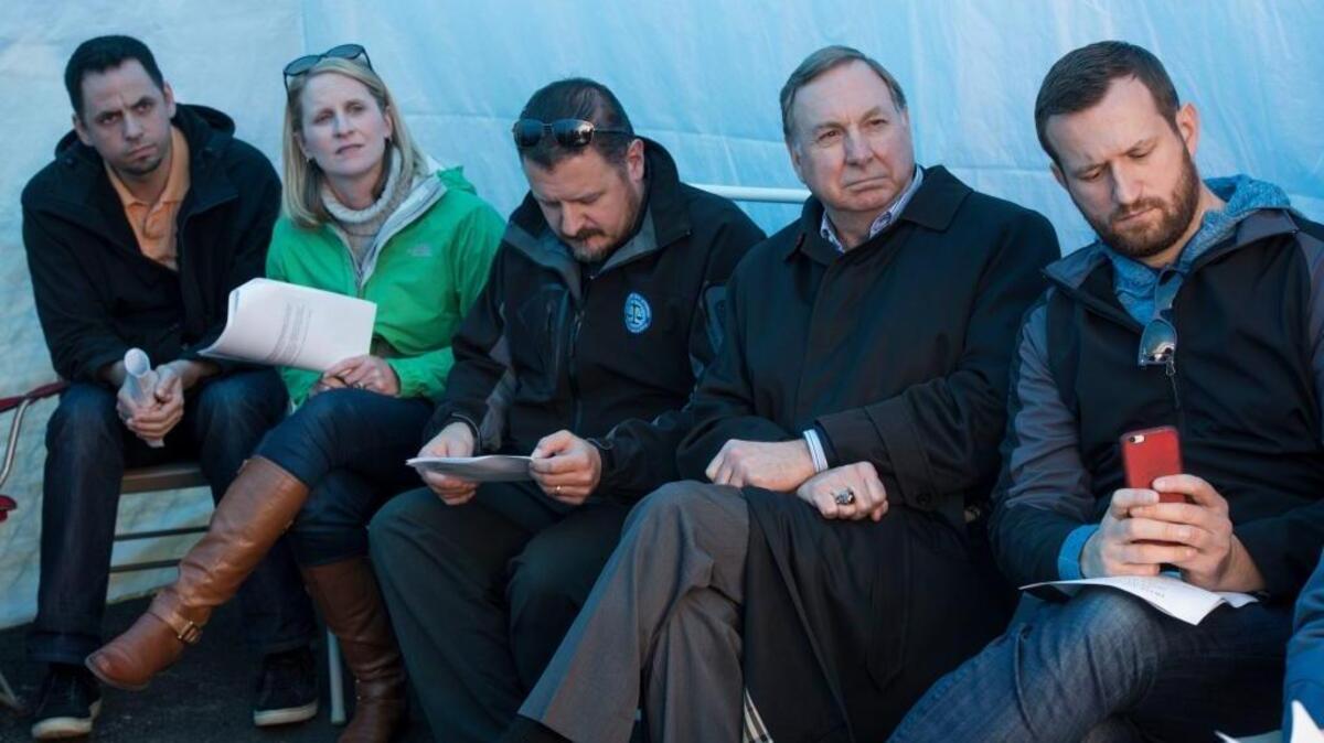 City Manager John Shirey, second from right, listens to a presentation about a tent city for the homeless in Seattle last month. He’s stepping down in November.