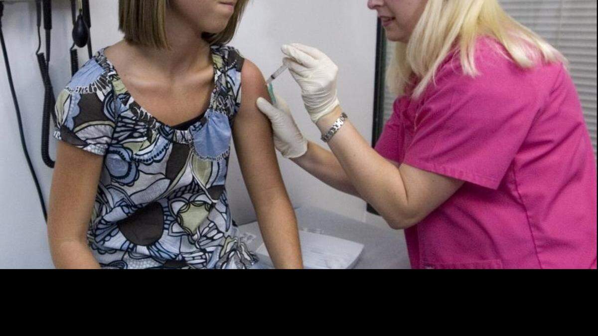 In this 2007 file photo, Lauren Fant, left, of Georgia, winces as she has her third and final application of the HPV vaccine, which has dramatically reduced the incidence of the virus that causes cervical cancer.