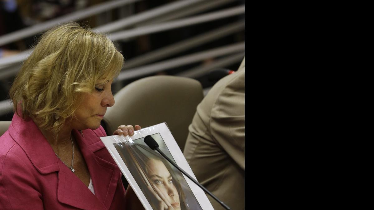 
Debbie Ziegler, the mother of Brittany Maynard, displays a photo of her daughter while appearing before the California Senate Health Committee in March. She urged lawmakers to approve legislation allowing doctors to prescribe life-ending drugs to terminally ill patients.
