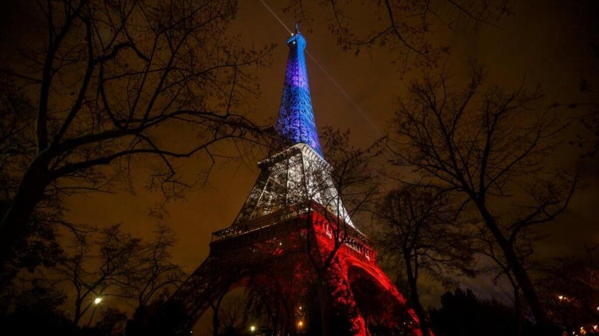 The Eiffel Tower illuminated in the French colors in honor of the victims of the terrorist attacks in Paris. The tragedy has prompted calls for more government surveillance power and weaker encryption on cellphones and messaging apps.