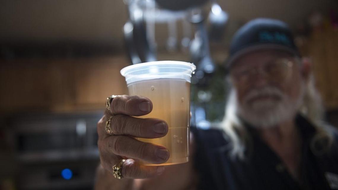 Ron Phillips shows the brown color of the tap water from his kitchen faucet, Sunday, May 27, 2018, at the Rancho Marina Mobile Home & RV Park in the Delta Loop of Isleton, about 40 miles south of Sacramento. Phillips said he's lived there for 30 years, but never seen it so bad. The park's owners have spent more than $500,000 on a new treatment system.