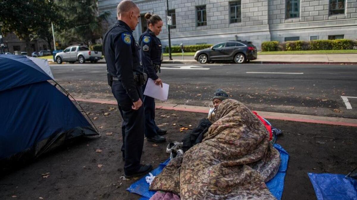 Ivan Dixon, who says he has been homeless for 31 years, is confronted by two police officers for camping outside of Sacramento City Hall. “It’s crazy man, there’s nowhere for me to be,” said Dixon, 45. “I used to have dreams to have children and a family, but none of that exists anymore.”