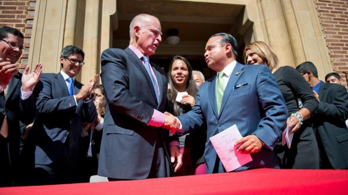 Gov. Jerry Brown congratulates Assemblyman Luis Alejo, D-Watsonville, in 2013 after signing his Assembly Bill 60 that requires the Department of Motor Vehicles to issue driver’s licenses to undocumented immigrants.