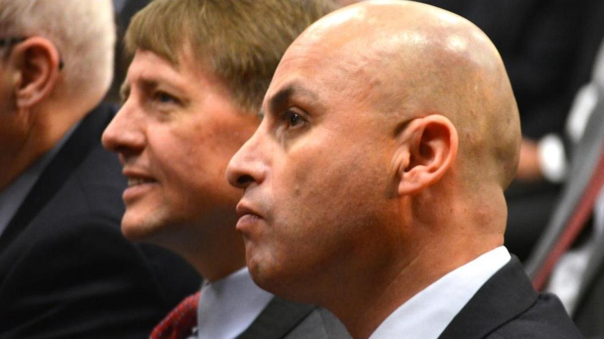 Consumer Financial Protection Bureau director Richard Cordray, left, and New Mexico Attorney General Hector Balderas, right, sit at the Albuquerque Convention Center Thursday before the bureau proposed to ban arbitration clauses that class-action lawsuits against financial firms over deceptive practices.