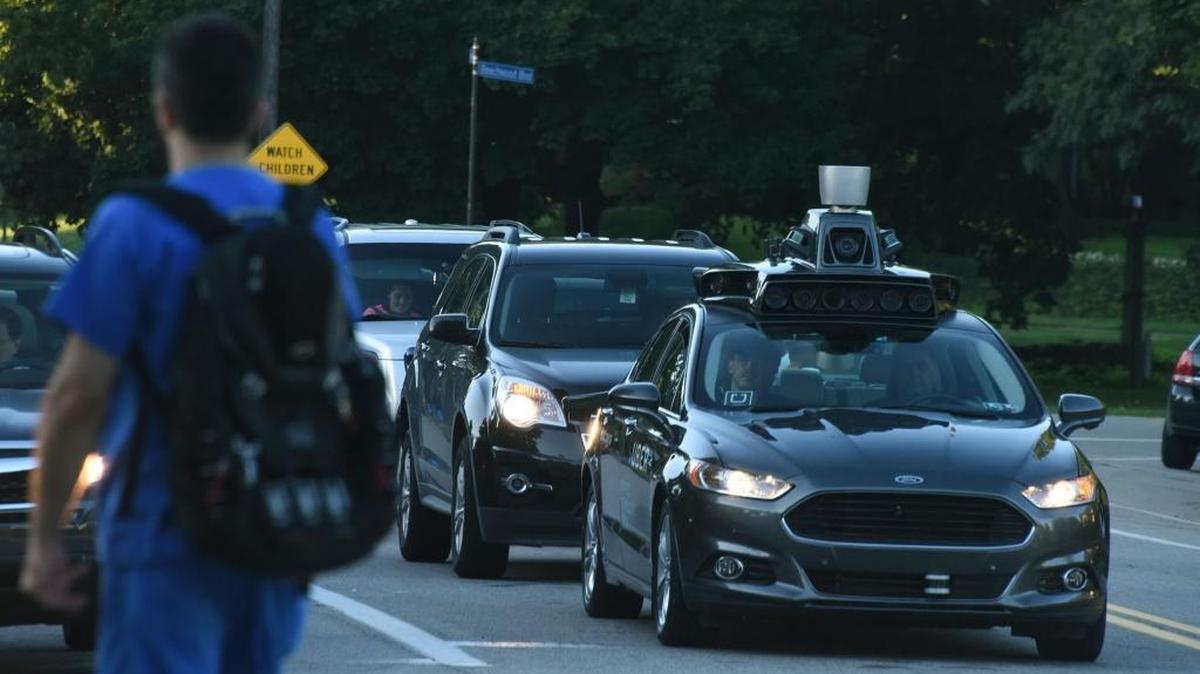 An Uber self-driving Ford Fusion sits at a traffic light in Pittsburgh.