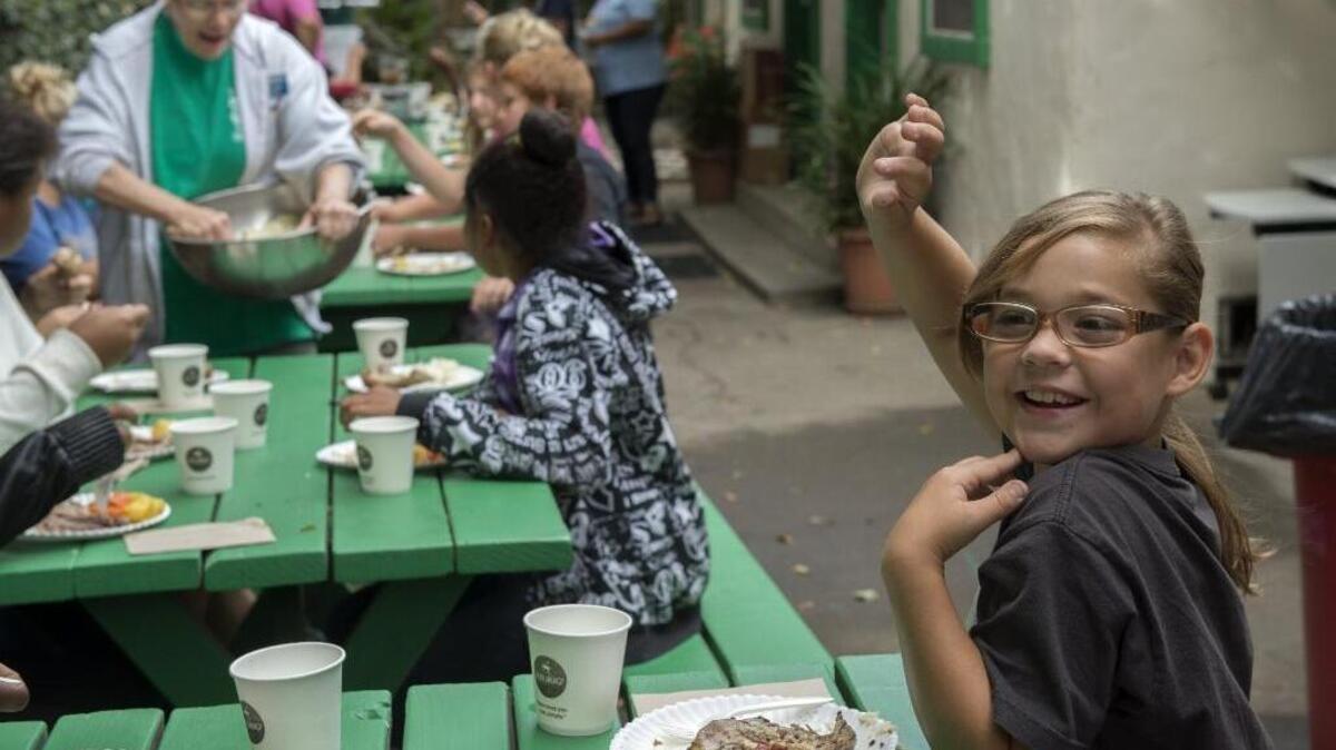 Clara McDonald, 9, raises her hand during lunch at Mustard Seed School, a nonprofit private school that has been educating Sacramento’s homeless children for 26 years and helping many of them transition to public schools.