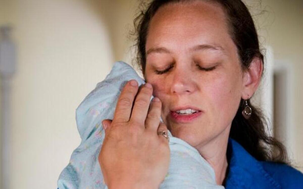 
Rachel Hansen, a midwife for Birthstream Midwifery Services, comforts 3-week-old Julia Davenport in 2013. Greater access to health care, particularly for people with Medi-Cal, remains a quandary.
