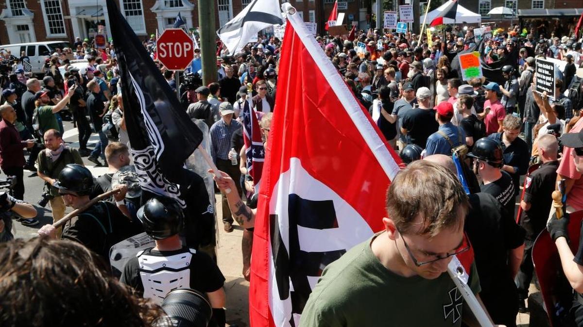 This Saturday, Aug. 12, 2017 image shows s white supremacist carrying a NAZI flag into the entrance to Emancipation Park in Charlottesville, Va. (AP Photo/Steve Helber)