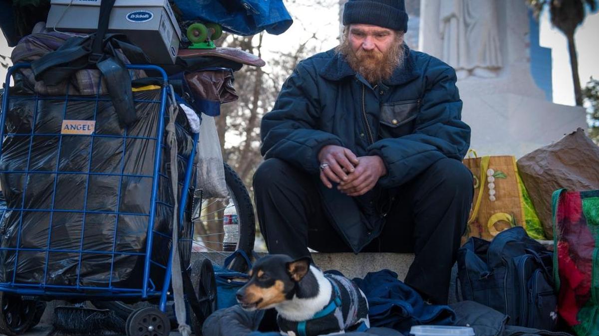 William Mercer sits with his dog Chico at Cesar Chavez Plaza after a friend who also was homeless man died Wednesday on the grounds of Sacramento City Hall. “I was one of the guys that always fed and took care of him,” he said. “Last night we fed him soup. Gave him some hot cocoa, coffee and stuff. I brought him a red and green blanket."
