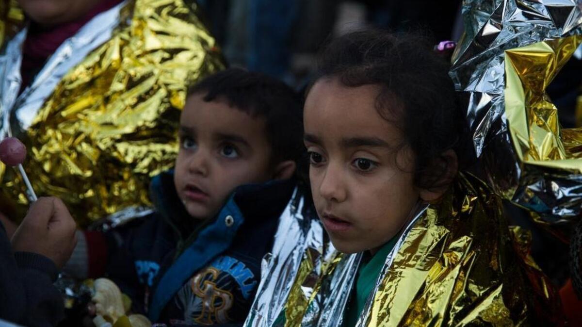 Children in thermal blankets sit on a beach on the Greek island of Lesbos shortly after crossing the Aegean sea on a dinghy from Turkey with other refugees.