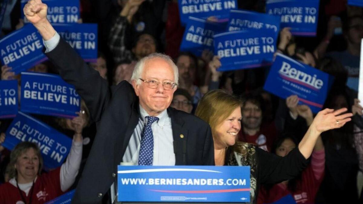 Sen. Bernie Sanders and his wife, Jane, acknowledge the crowd as he arrives for his caucus night rally in Des Moines, Iowa, on Feb. 1.