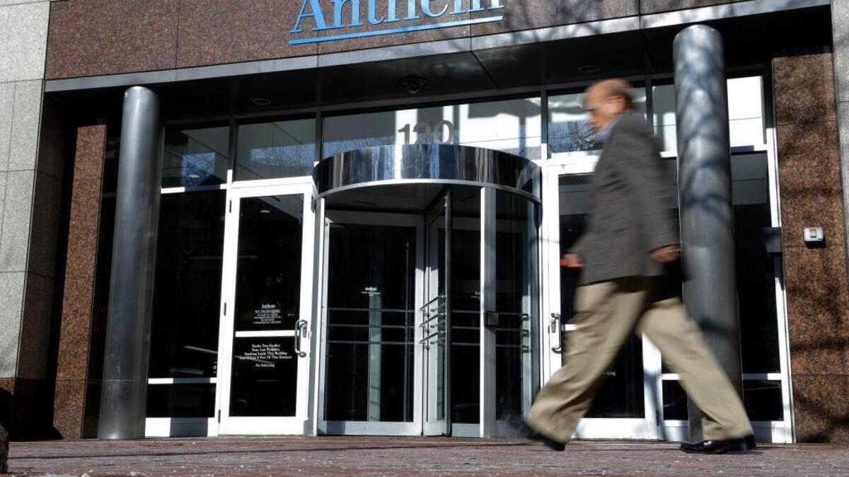 A man walks past health insurer Anthem's corporate headquarters in Indianapolis. The health insurance giant wants to merge with Cigna, in one of two mega-deals in the industry the Justice Department has sought to block.