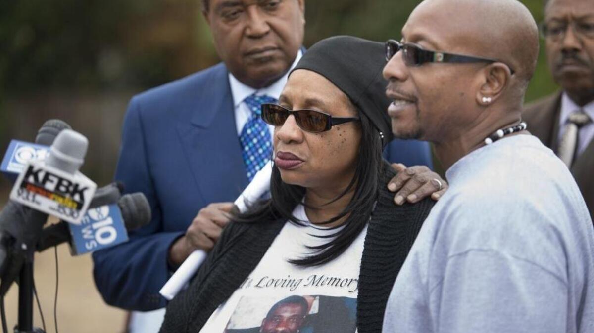 Robert Mann, right, stands with civil rights attorney John Burris, left, and his sister, Deborah Mann, while talking about his brother, Joseph. The two officers who shot Joseph Mann last summer are no longer with the Sacramento Police Department.