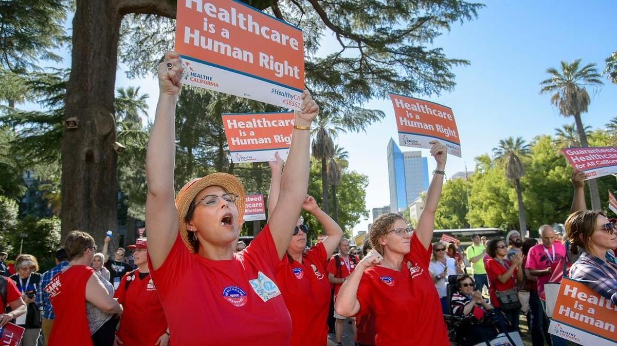 NICU nurse Loretta Dragon, left, and wife Jackie Dragon of Oakland cheer speakers during a rally supporting Senate Bill 562 on the west steps of the state Capitol in Sacramento on Friday. SB 562 would create a universal single-payer health care system in California.