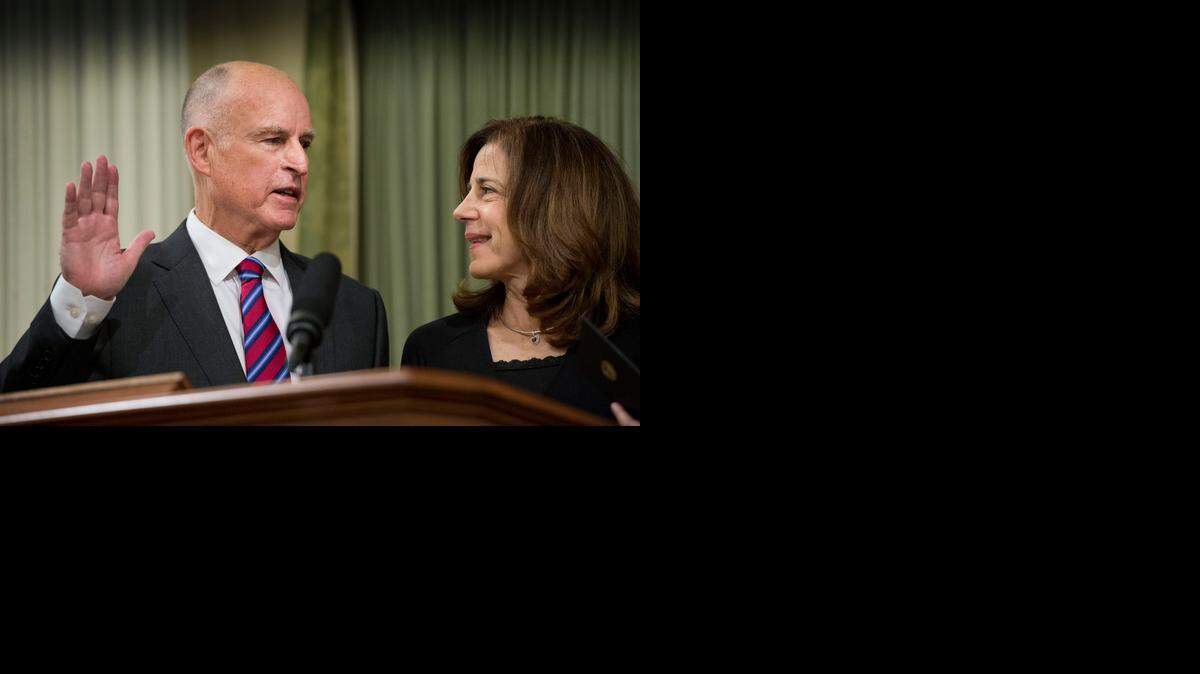 
Gov. Jerry Brown is sworn in to office Monday as first lady Anne Gust Brown holds her family Bible.
