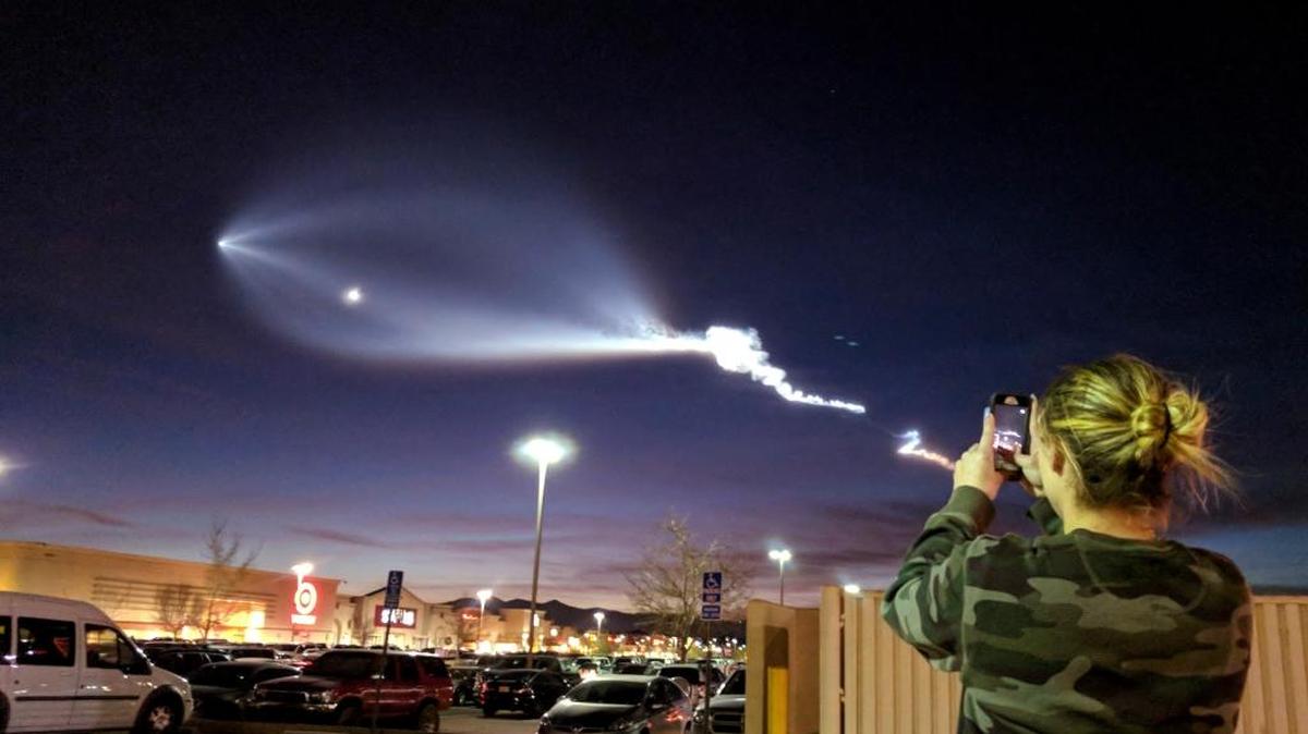An employee at a hair salon takes pictures of a SpaceX rocket launched from Vandenberg Air Force Base on Friday. The billowing cloud that followed it could be seen throughout Southern California and into Arizona, raising fears of an alien invasion.