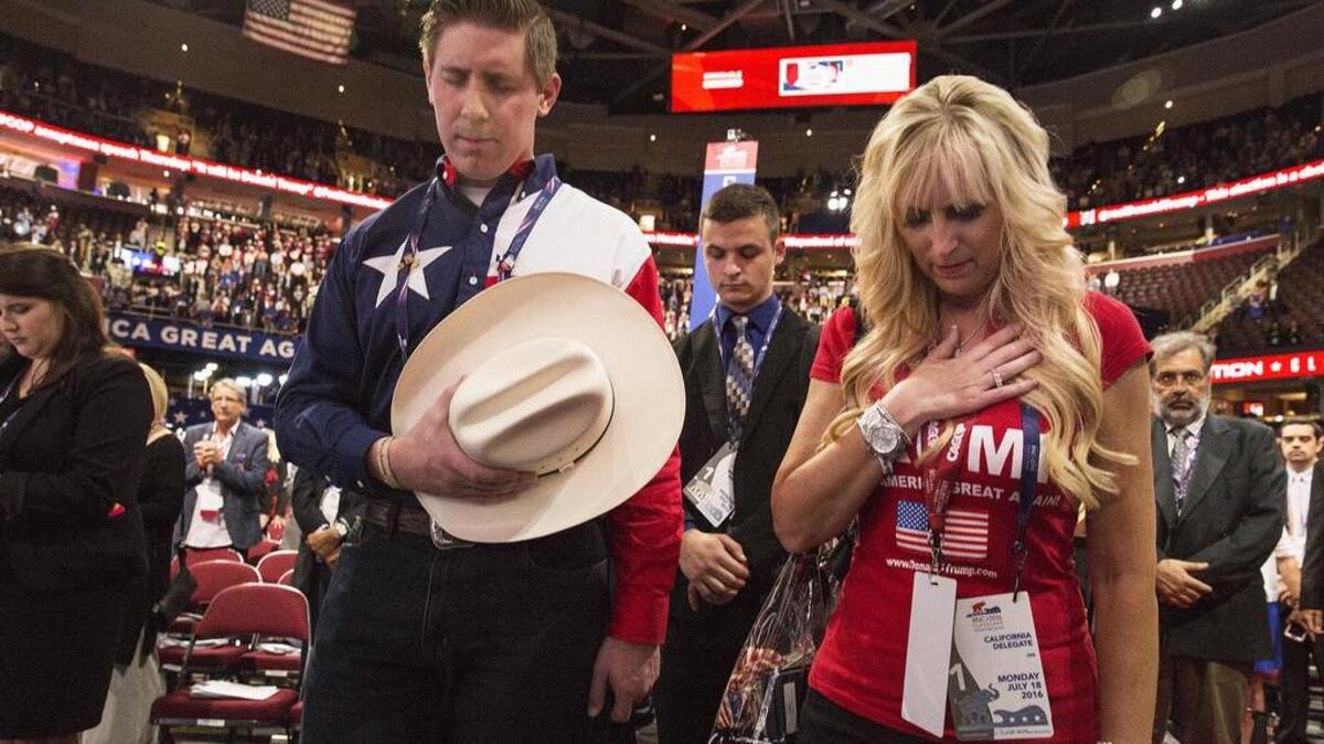 California delegate Shari Clark and Texas delegate David Covey bow their heads in prayer at the Republican National Convention in Cleveland.