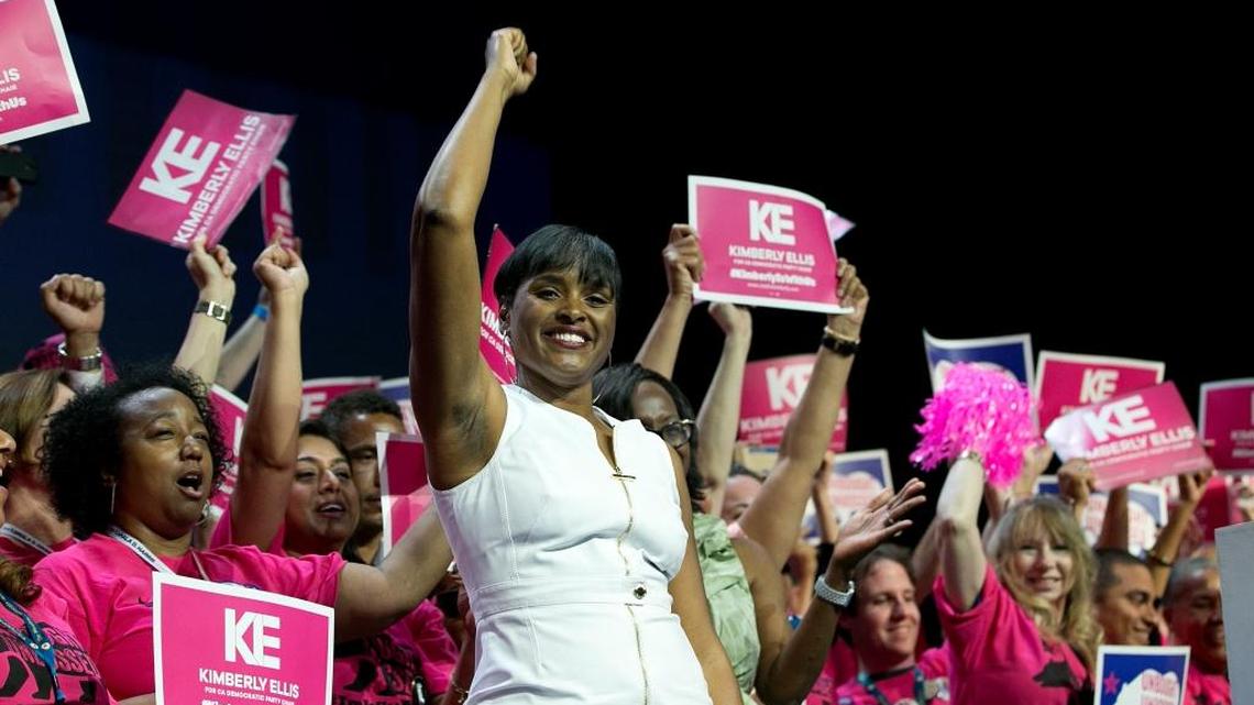 Surrounded by supporters, Kimberly Ellis waves after addressing delegates during the California Democratic Party convention in May.