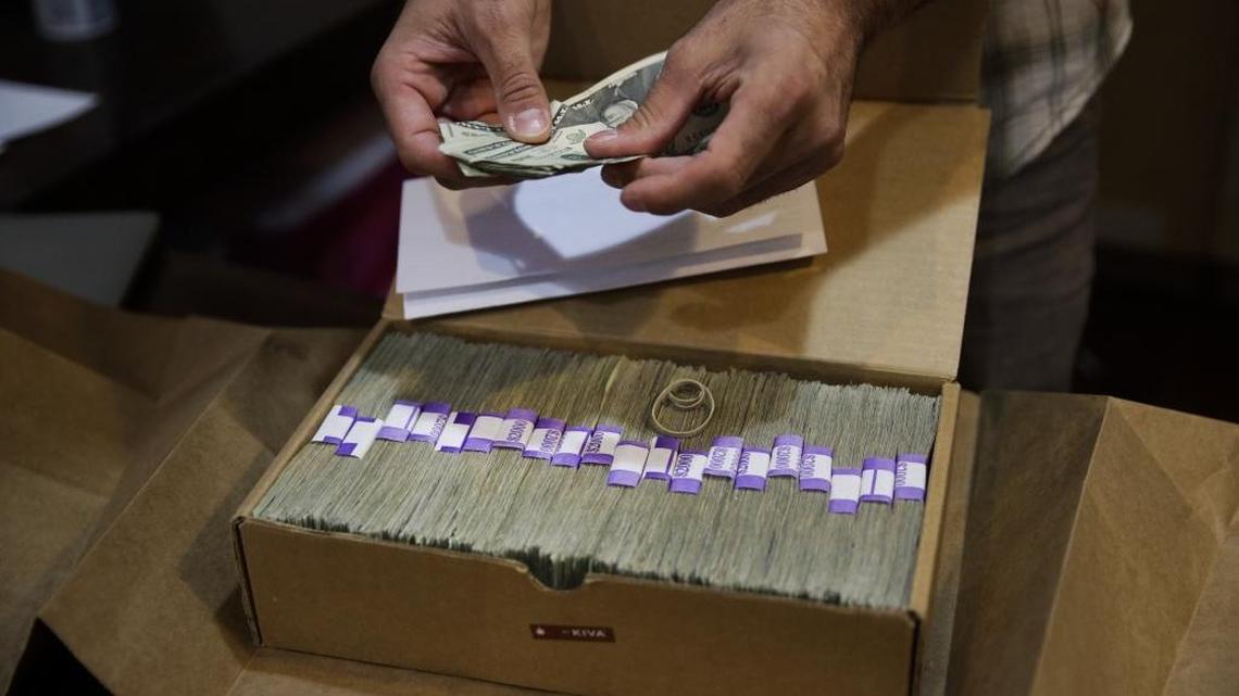 An owner of a medical marijuana dispensary in Los Angeles prepares his monthly tax payment, which he has to make in cash.