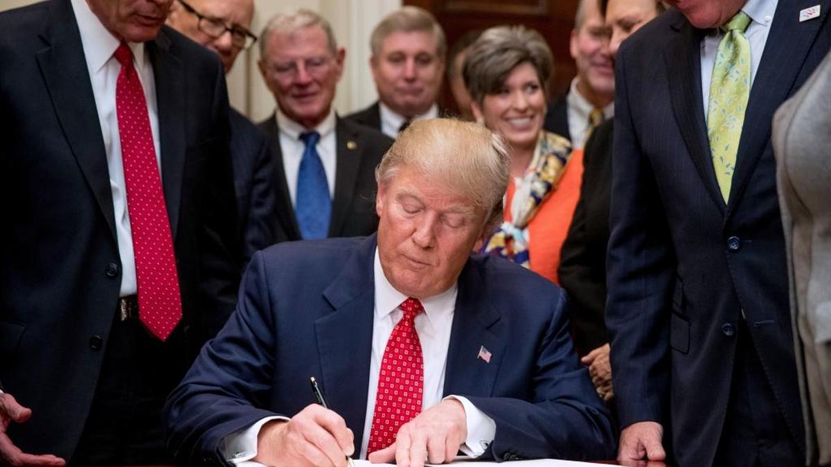 President Donald Trump signs an executive order directing the EPA to start dismantling rules that protected many waterways under the federal Clean Water Act.