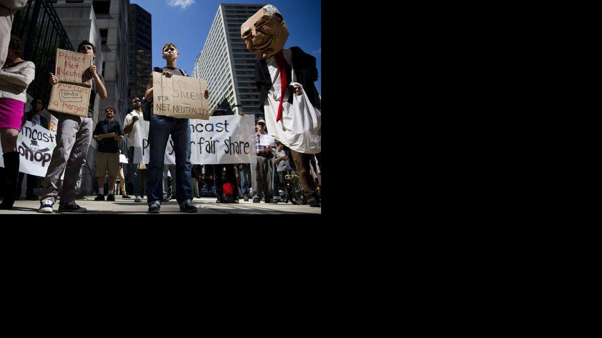 
Demonstrators opposed to the merger of Comcast Corp. and Time Warner Cable Inc. gather across the street from the Comcast Center in Philadelphia in September. A decision on the proposed $45 billion merger is thought to be relatively near.
