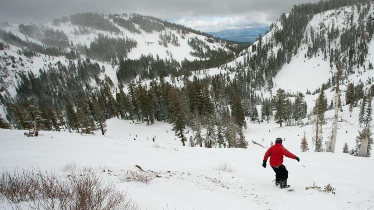 A snowboarder drops into a canyon near Lake Tahoe in 2012. Snowpack in the Sierra Nevada this season exceeds normal for the first time in years.