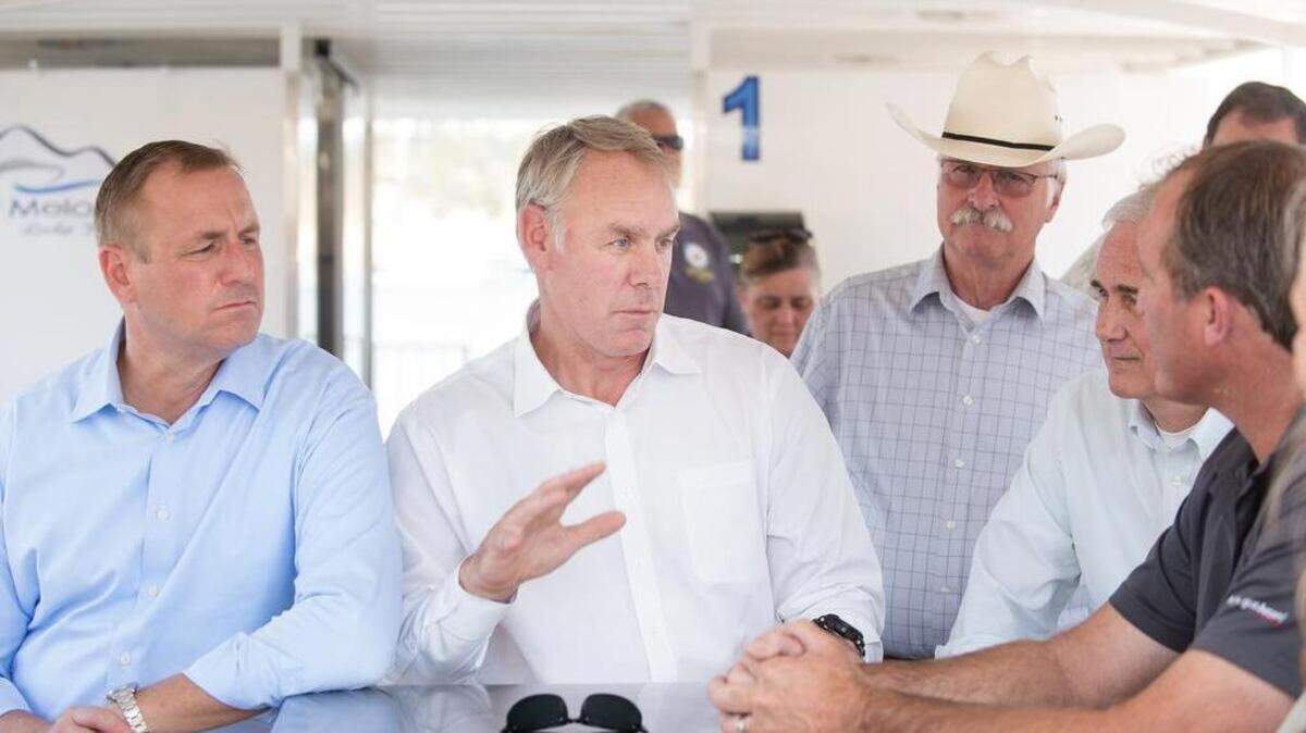 Interior Secretary Ryan Zinke talks with marina owner Darin Mills, right, at New Melones reservoir in July. Rep. Jeff Denham is at left and Rep. Tom McClintock is second right.