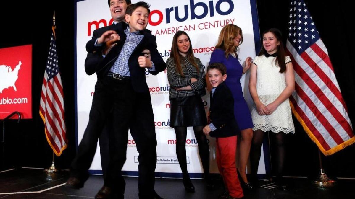 Sen. Marco Rubio of Florida lifts his son Anthony, 10, at a caucus night rally Monday in Des Moines, Iowa. He finished a strong third and put in his claim to be the Republican establishment favorite.