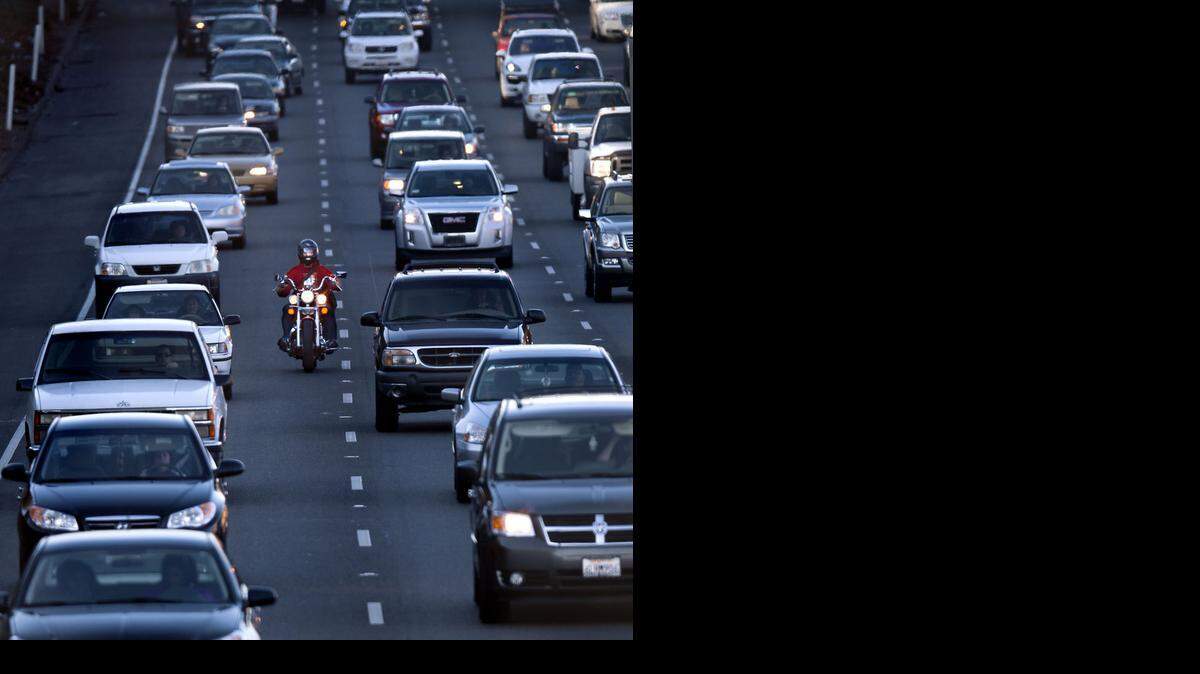 
A motorcyclist rides between the lanes during the afternoon commute on Highway 99. 
