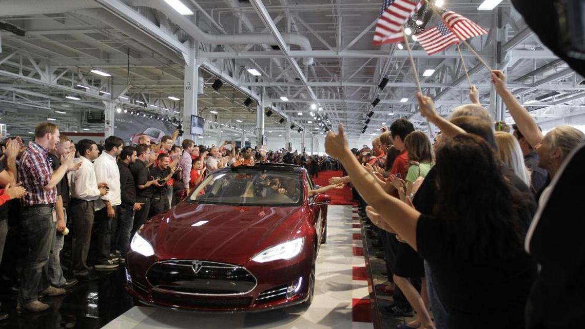 Tesla workers cheer on the first Tesla Model S cars sold during a rally at the Tesla factory in Fremont. The company has been the biggest beneficiary of a state tax break to exempt sales taxes on manufacturing equipment in the green technology sector.
