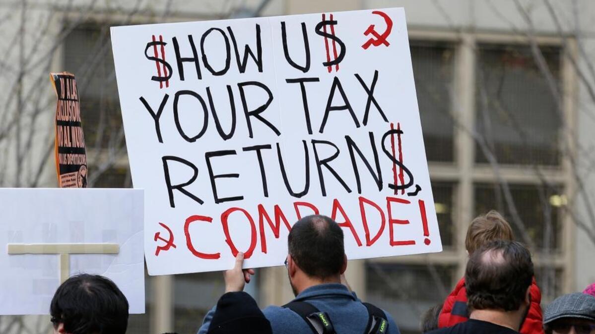 A protester in Seattle holds a sign during one of many rallies across the nation on Saturday calling on President Donald Trump to release his tax returns.