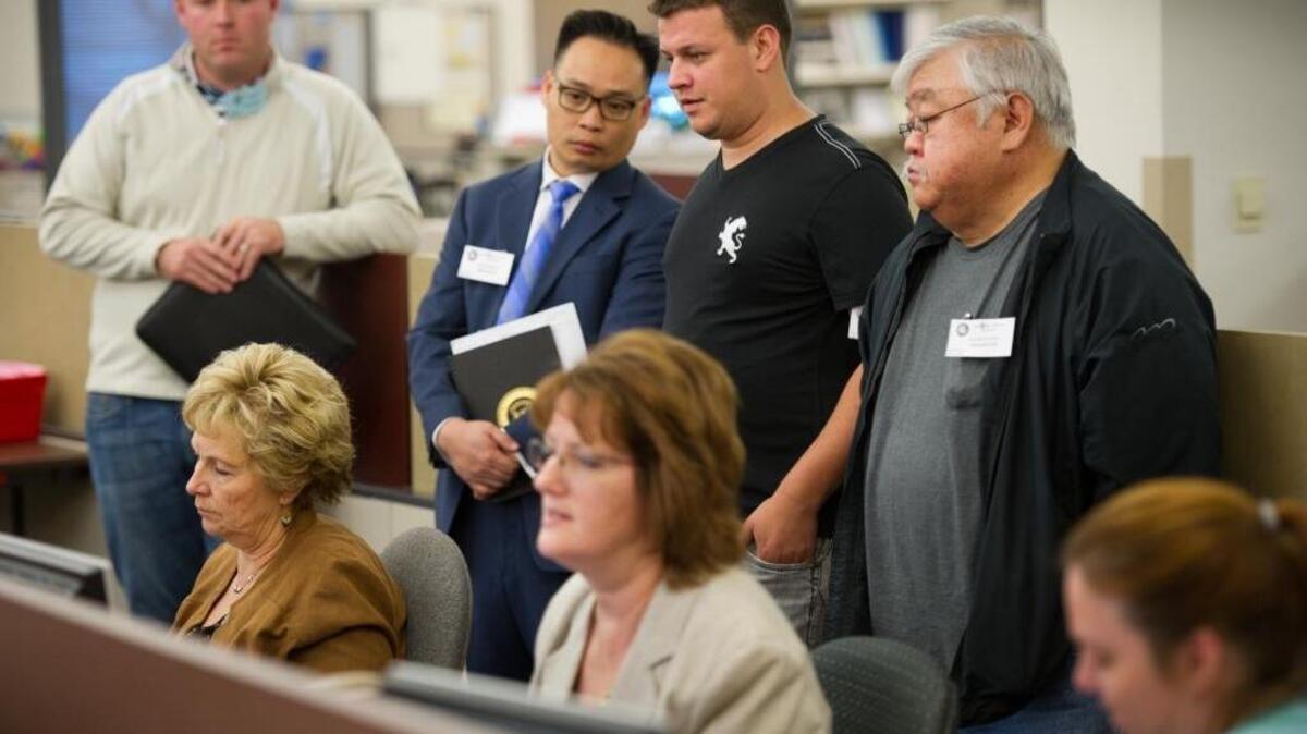 Observers watch and take notes as they line up behind election officials including Registrar Jill LaVine, left, as they verify ballots in November 2012.