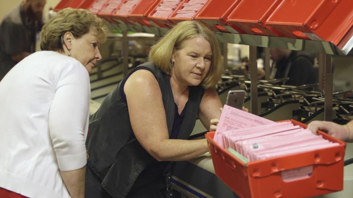 Sacramento County Registrar of Voters Jill LaVine, left, and Kim Alexander of the California Voter Foundation look over mail-in ballots that arrived after the June 7 primary in California.