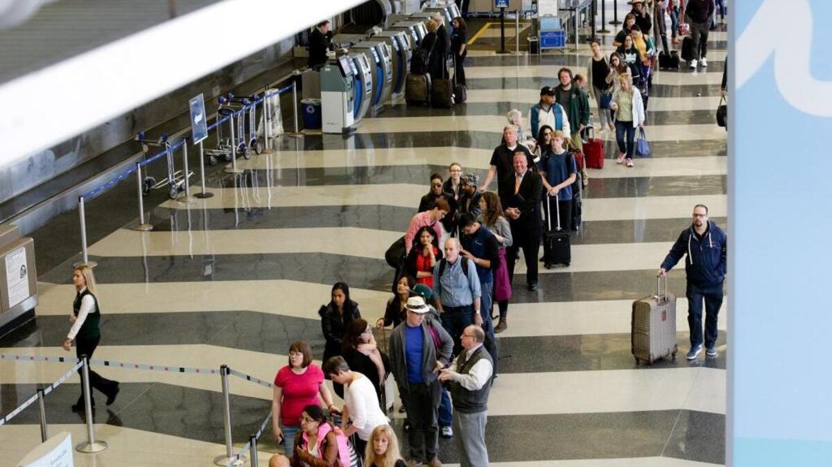 Travelers wait in line to reach an understaffed TSA security checkpoint at O'Hare International Airport in Chicago. At airports around the country, thousands have missed their flights waiting in long lines.