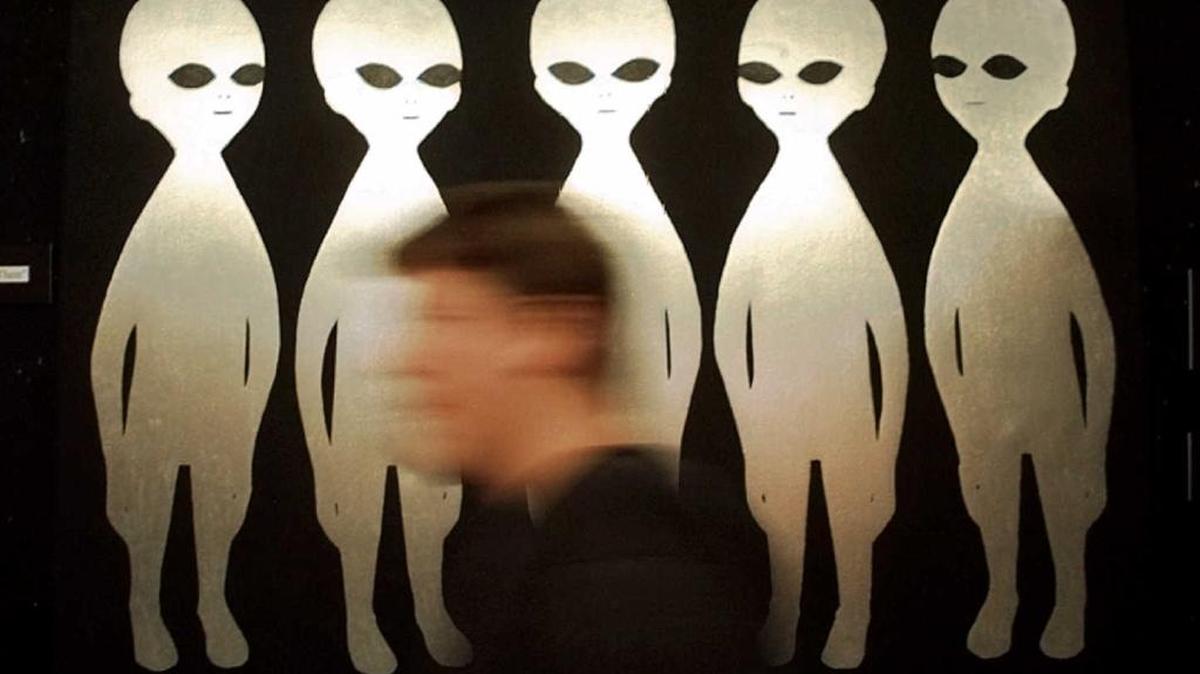 A patron passes a painting inside the International UFO Museum and Research Center in Roswell, N.M., the small-town site of an alleged UFO crash.