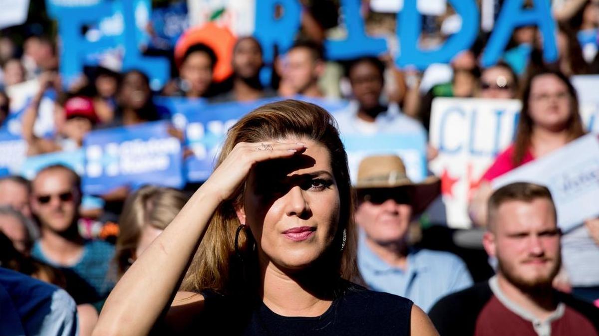 Alicia Machado, who won the Miss Universe pageant in 1996, listens as Democratic presidential candidate Hillary Clinton speaks at a campaign rally at Pasco-Hernando State College in Dade City, Fla., on Tuesday, Nov. 1, 2016.