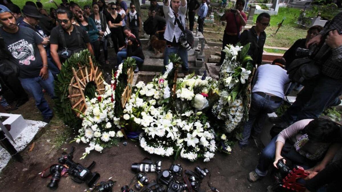 Photographers place their cameras over the grave of murdered photojournalist Ruben Espinosa during his funeral service in Mexico City in August. Outside combat zones, Mexico is one of the world’s most dangerous countries for reporters.