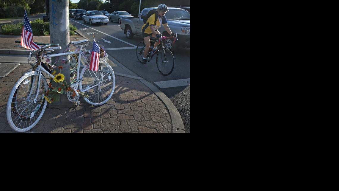 
A cyclist passes a “ghost bike” and its “companion bike” sitting chained to a light pole at the entrance to Sacramento State on J Street. The bikes mark the intersection where student Arlene Sasse, 22, was killed by a car in 2011. Sacramento ranks 26th out of 52 large cities surveyed with 5.3 fatalities a year per 10,000 bicycling commuters.
