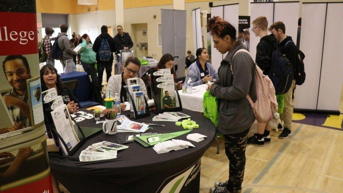 A prospective student stops by a Sierra College table at a college fair.