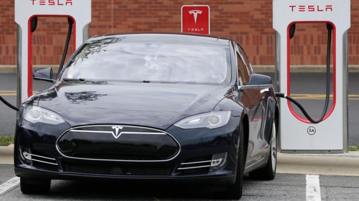 A Tesla recharges at a charging station at Cochran Commons shopping center in Charlotte, N.C.