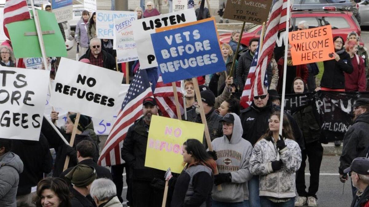 Protesters on opposing sides of the Syrian refugee resettlement issue rally in front of the state Capitol in Olympia, Wash., on Nov. 20. Washington Gov. Jay Inslee has said the state will welcome refugees and has criticized other governors who have threatened to stop accepting them following the recent terror attacks in Paris.