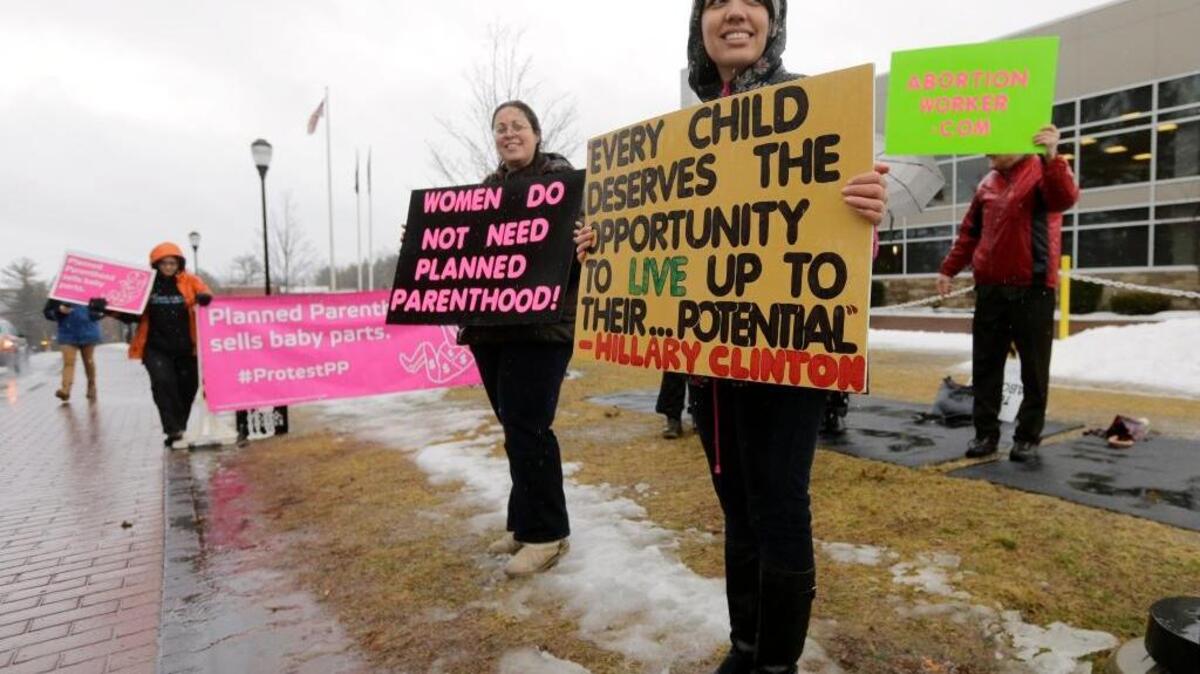 Protesters against Planned Parenthood line the road outside a venue where Democratic presidential candidate Hillary Clinton was scheduled to speak in Hooksett, N.H.