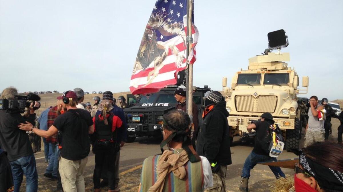 Dakota Access Pipeline protesters defy law enforcement officers who are trying to force them from a camp on private land in the path of pipeline construction last week near Cannon Ball, N.D. The months-long dispute over the four-state, $3.8 billion pipeline reached a crisis point when the protesters set up camp on land owned by pipeline developer Energy Transfer Partners.