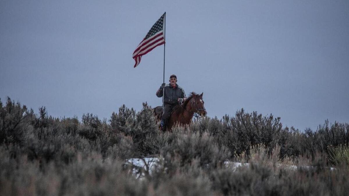 An armed man going by his first name only, Dwayne, rides near the entrance to Malheur National Wildlife Refuge last week. Armed ranchers protesting the federal government’s claim on public land have taken over a federal building there.