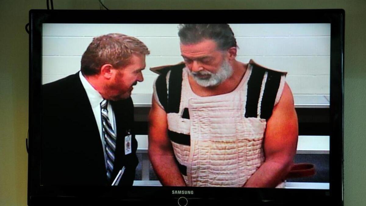 Colorado Springs shooting suspect Robert Dear, right, appears via video with public defender Dan King before Judge Gilbert Martinez in his first court appearance Monday. Dear learned he faces three first-degree murder charges in the killings of three people last week at a Planned Parenthood clinic.