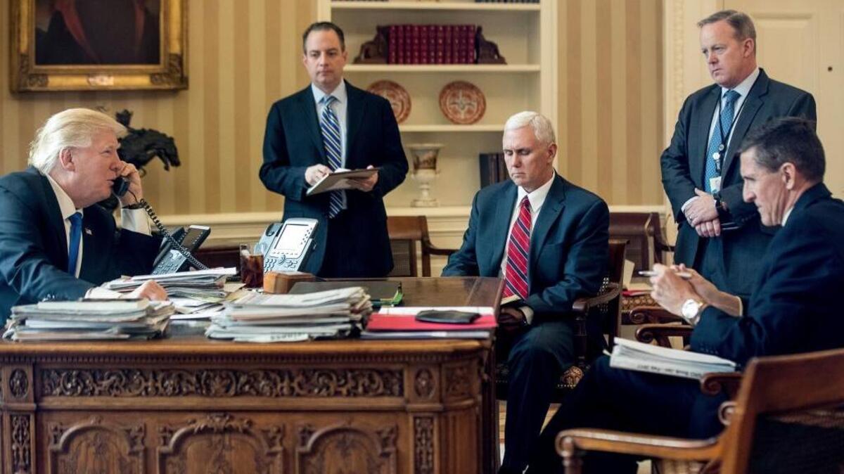 Donald Trump with, from second from left, Chief of Staff Reince Priebus, Vice President Mike Pence, White House press secretary Sean Spicer and then-National Security Adviser Michael Flynn speaks on the phone with Russian President Vladimir Putin, in the Oval Office. Trump's White House is nearly paralyzed by crisis, divisions and dysfunction, and virtually all policy announcements have slowed to a crawl.